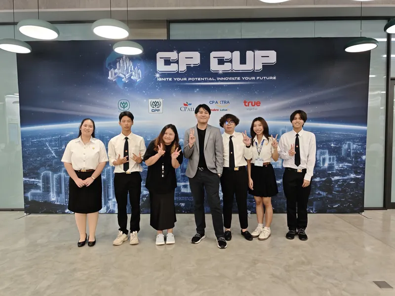 กลุ่มผู้เข้าร่วมเจ็ดคนยืนถ่ายภาพหน้าฉากหลังงาน CP CUP